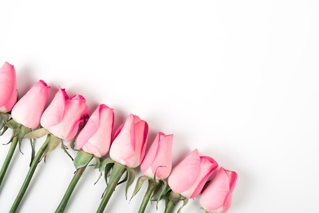 Ramas de rosas rosadas en mesa de luz