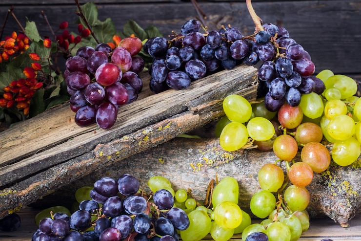 Foto gratuito ramita de uvas sobre fondo de madera