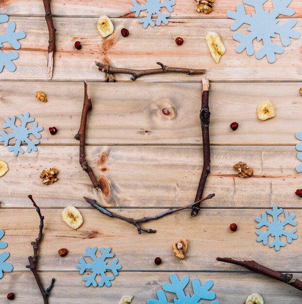 Ramitas entre copos de nieve decorativos.