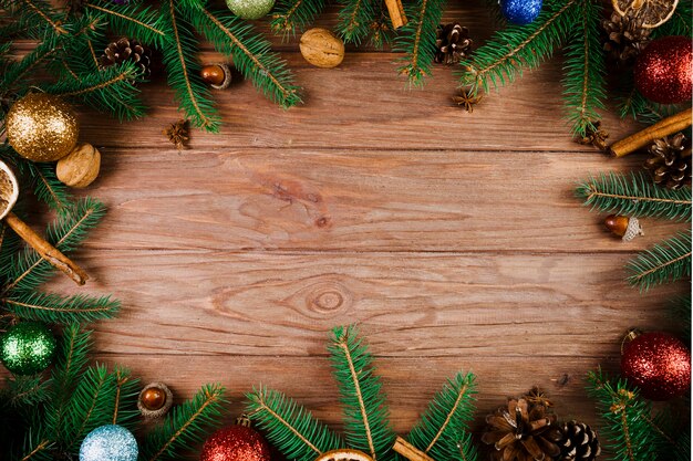 Ramitas de Navidad y bolas de adorno en el escritorio de madera