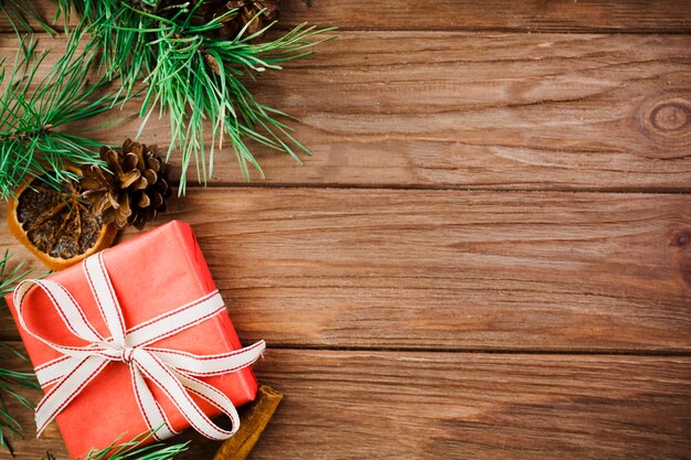 Ramitas de Navidad y caja roja en escritorio de madera