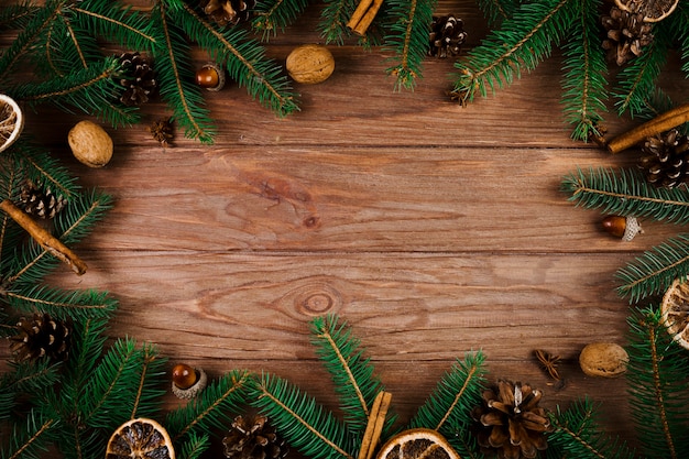 Ramitas de Navidad y nueces en escritorio de madera