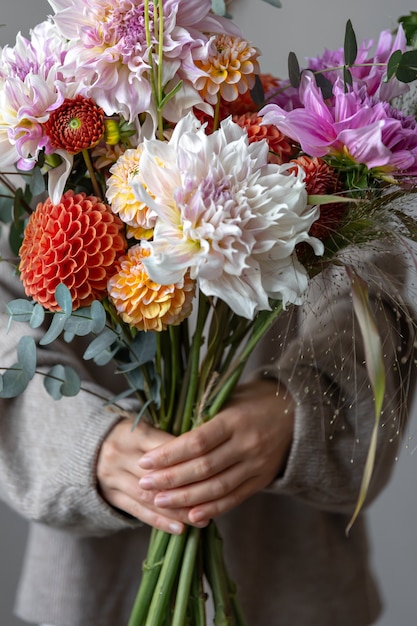 Ramo festivo brillante con flores de crisantemo en manos femeninas, el concepto de la fiesta del día de la mujer.