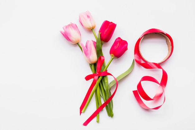 Ramo de flores frescas brillantes en tallos cerca de rollo de cinta