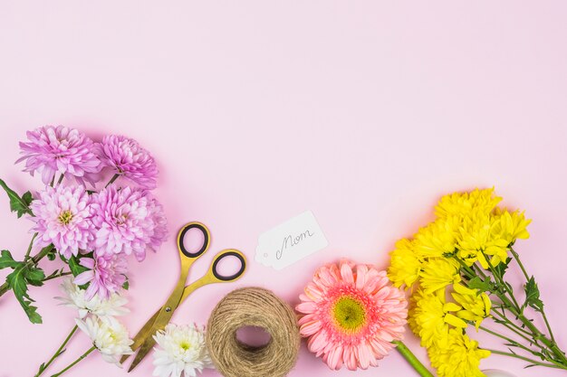 Foto gratuita ramo de flores frescas cerca de la etiqueta con la palabra mamá y tijeras