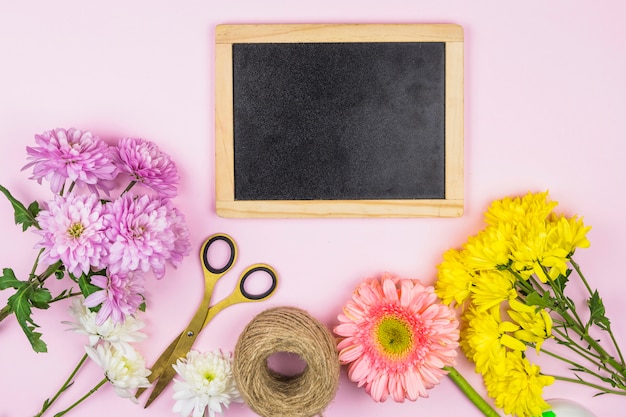 Foto gratuita ramo de flores frescas cerca de tijeras y marco de fotos