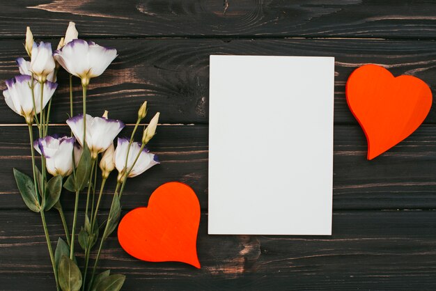 Ramo de flores con papel y corazones en mesa.