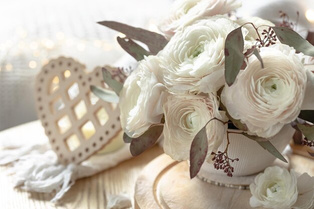 Foto gratuita ramo de flores de ranúnculo blanco en un fondo borroso con un corazón