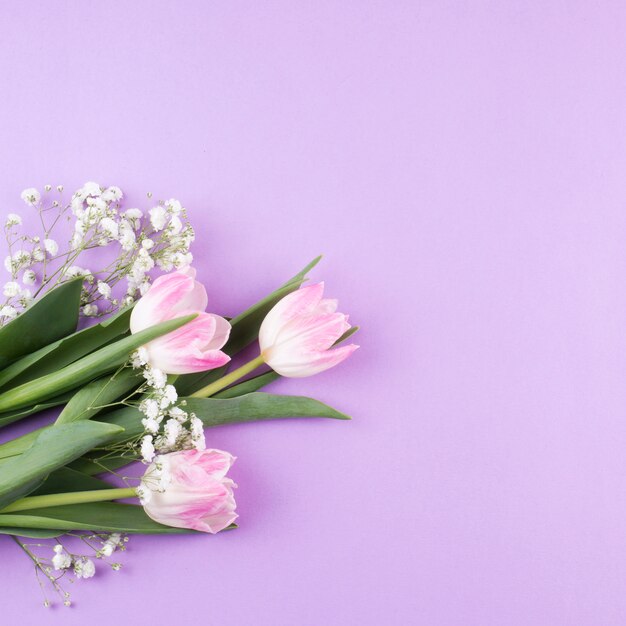 Ramo de flores de tulipán con ramas en mesa