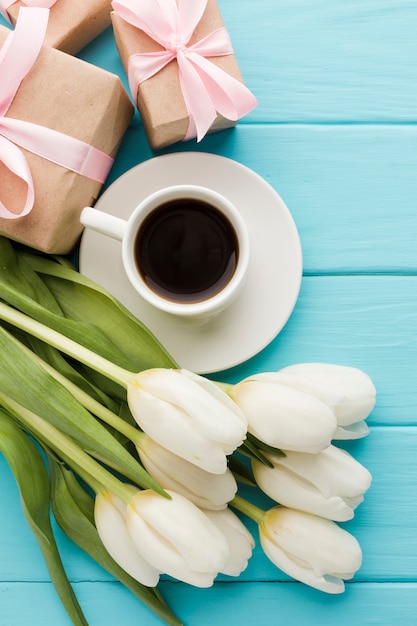 Ramo de flores de tulipán con taza de café y regalos