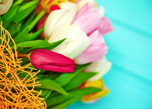 Ramo de flores de tulipanes multicolores frescas en la vieja mesa de madera azul