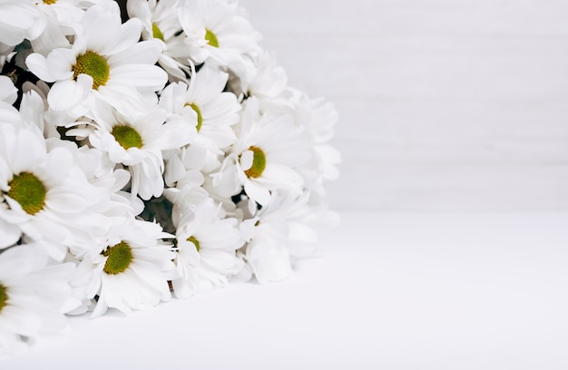 Ramo hermoso fresco de la flor de la margarita blanca en el escritorio blanco