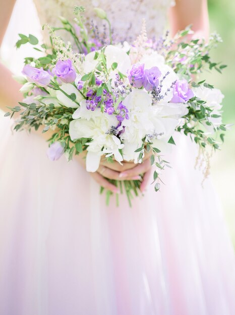 Ramo de lavanda y rosas blancas en los brazos de la novia
