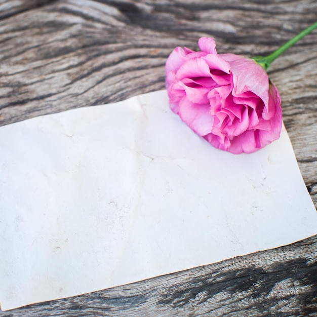 Ramo de lisianthus en una mesa de madera con nota en blanco