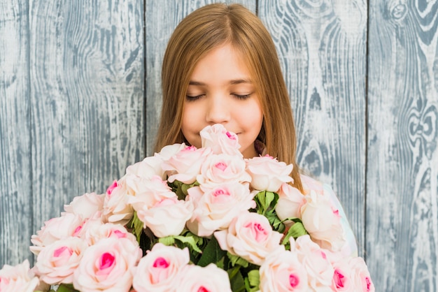 Foto gratuita ramo que huele de la muchacha de rosas