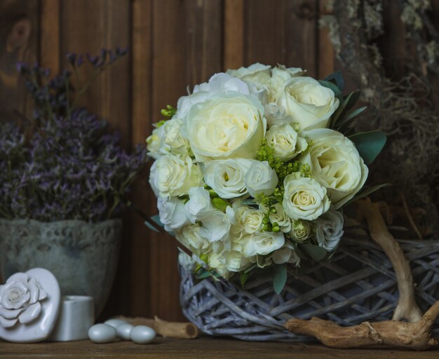 Foto gratuita ramo de rosas blancas sobre muebles rústicos