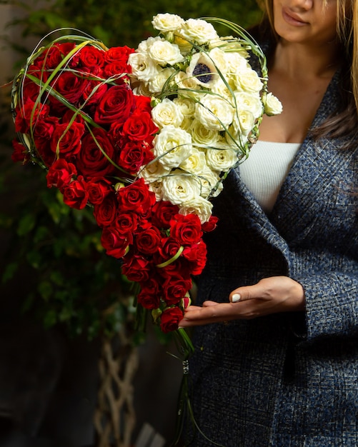 Foto gratuita ramo de rosas rojas y blancas en forma de corazón