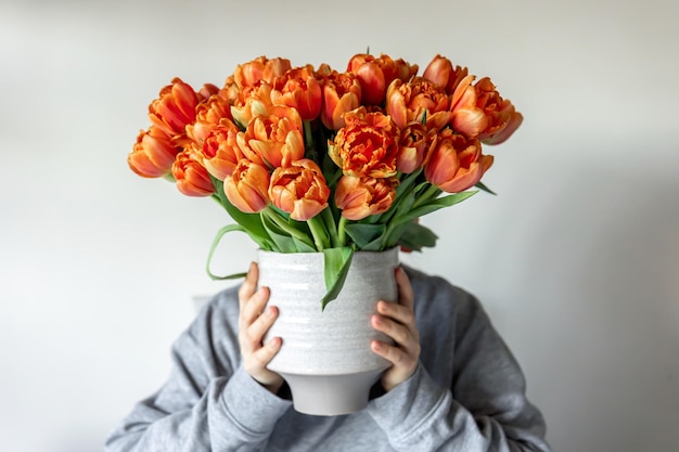 Ramo de tulipanes naranjas frescos en manos femeninas primer plano