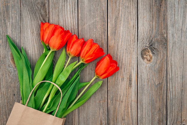 Foto gratuita ramo de tulipanes rojos en una vista superior de fondo de madera