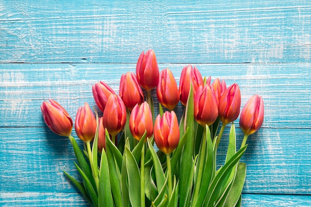 Foto gratuita ramo de tulipanes rosas en una vista superior de fondo de madera azul
