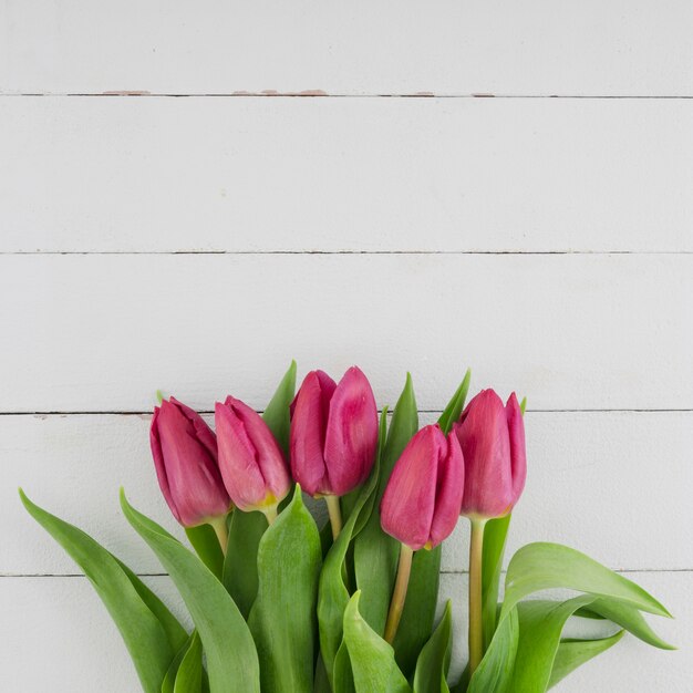 Ramo de tulipanes sobre fondo de madera