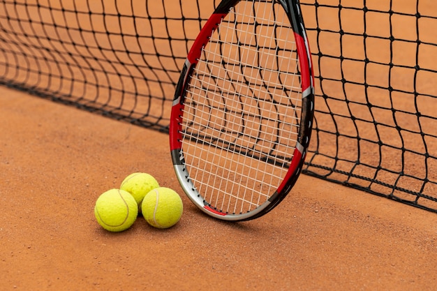 Raqueta de primer plano con pelotas de tenis