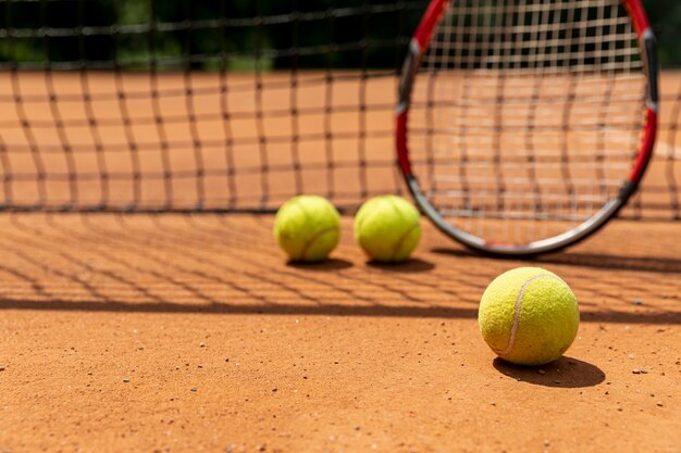 Raqueta de primer plano con pelotas de tenis