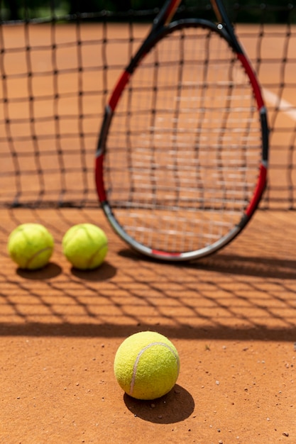 Raqueta de primer plano con pelotas de tenis