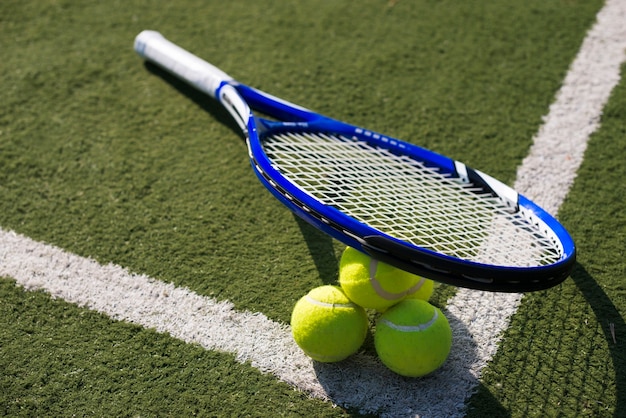 Raqueta de tenis de alto ángulo y pelotas