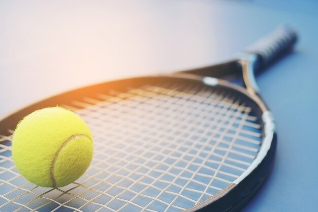 Raqueta de tenis con pelota en la cancha