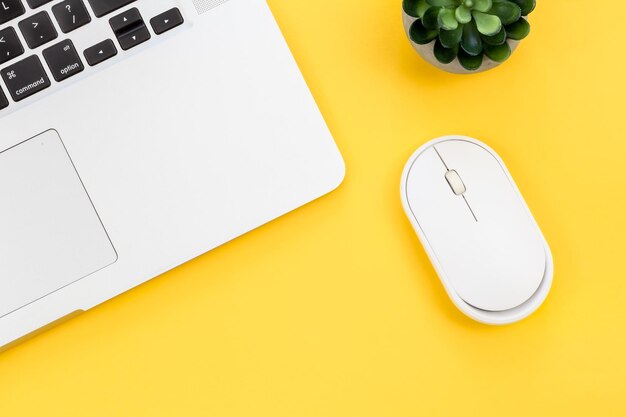 Ratón de computadora y computadora portátil sobre un fondo amarillo aislado plano