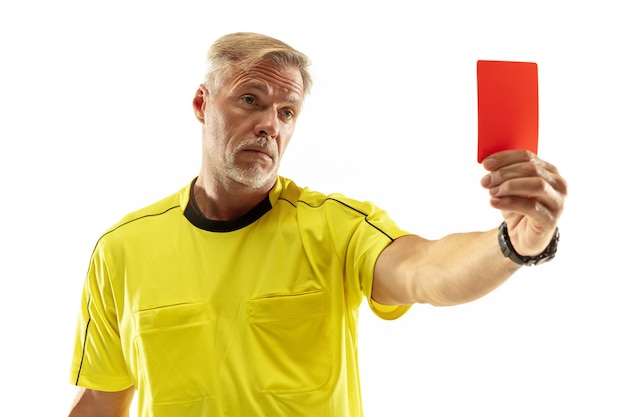 Árbitro que muestra una tarjeta roja a un jugador de fútbol o fútbol disgustado mientras juega aislado sobre fondo blanco de estudio.