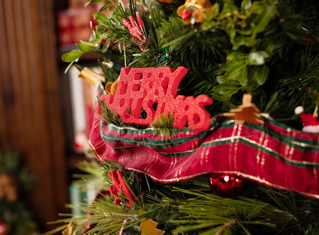 Árbol con letras de "merry christmas" en rojo