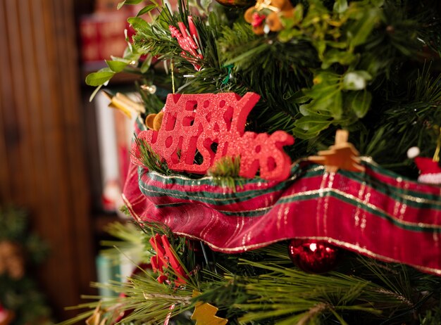 Árbol con letras de "merry christmas" en rojo