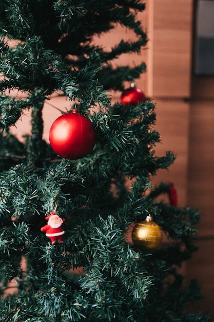 Árbol de navidad con bolas doradas y rojas y santa.