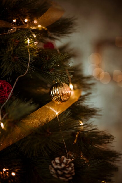 Árbol de navidad decorado con cinta dorada y guirnalda.