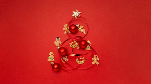Árbol de Navidad hecho con galletas de Navidad y bolas de Navidad en mesa roja