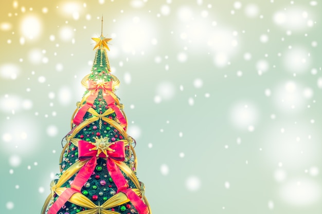 Árbol de navidad con lazos grandes en un fondo azul con luces