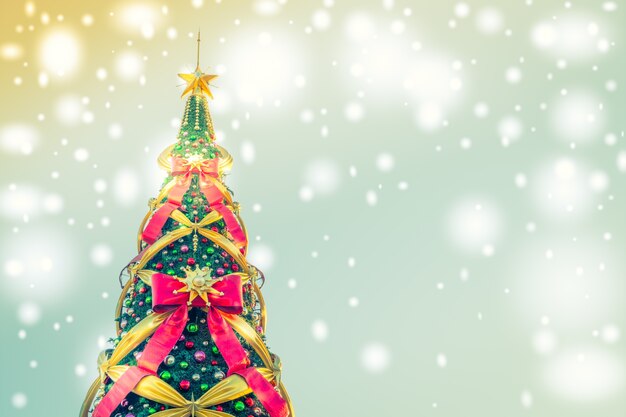 Árbol de navidad con lazos grandes en un fondo azul con luces