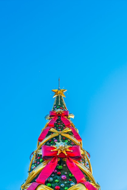 Árbol de navidad con lazos grandes en un fondo azul