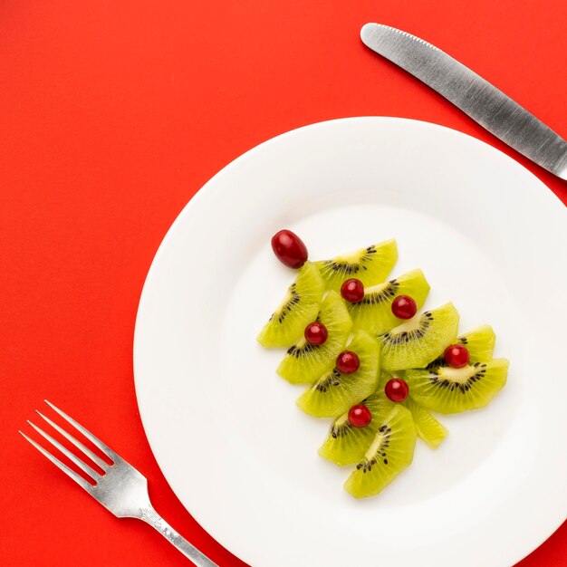 Árbol de Navidad en plato blanco hecho con diferentes ingredientes