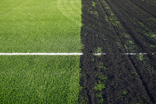 Realización de un campo de fútbol de césped artificial con superficie de césped sintético verde y gránulos de caucho