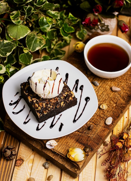 Una rebanada de brownie de chocolate con helado de nuez y vainilla.