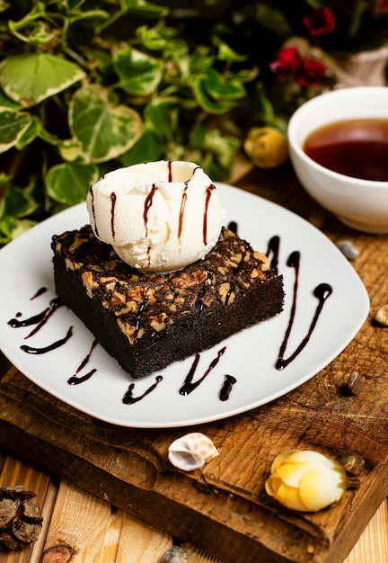 Una rebanada de brownie de chocolate con helado de nuez y vainilla.