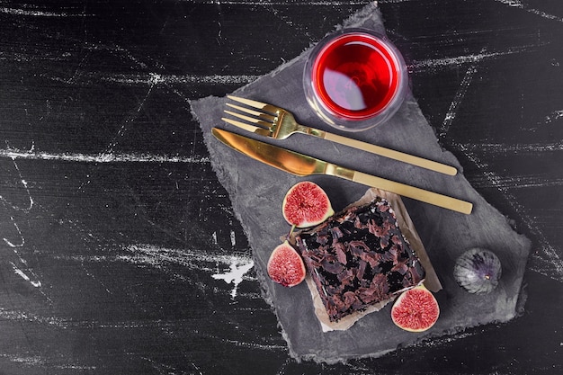 Una rebanada cuadrada de tarta de queso de chocolate con bebida roja