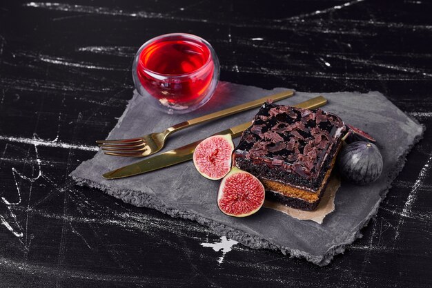 Una rebanada cuadrada de tarta de queso de chocolate con una copa de vino.