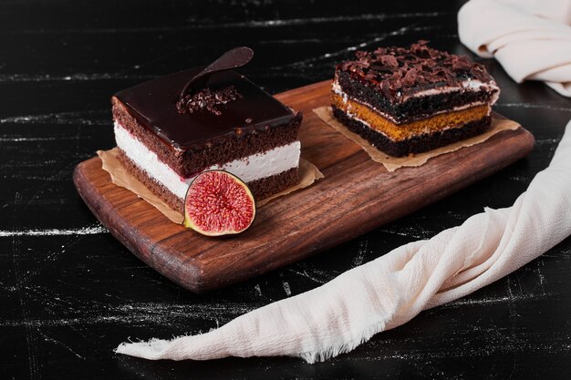 Una rebanada cuadrada de tarta de queso con chocolate sobre una tabla de madera.