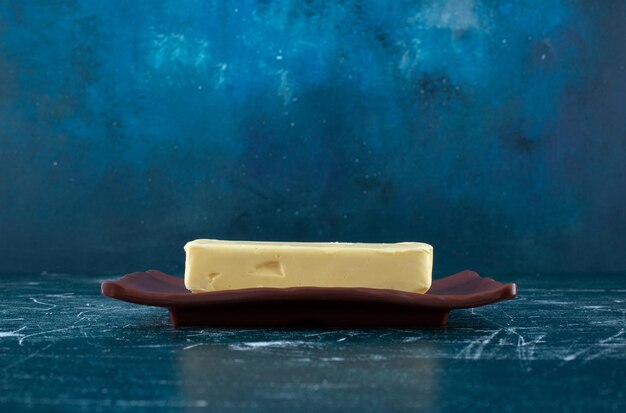 Una rebanada de mantequilla casera en un plato de cerámica.