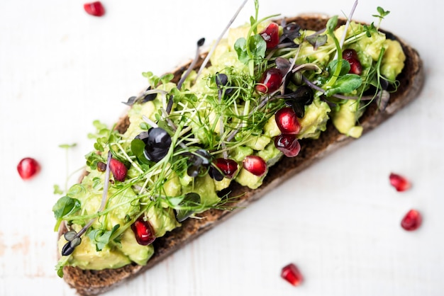 Foto gratuita rebanada de pan con pasta de aguacate y verduras alta vista