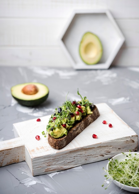 Rebanada de pan con pasta de aguacate y verduras